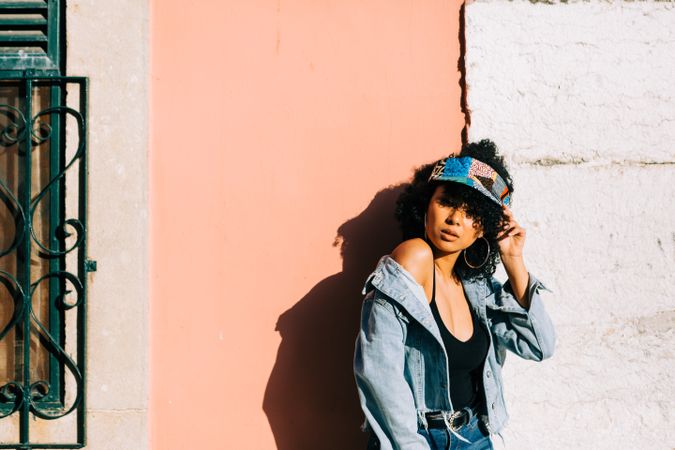 female leaning on wall and holding head