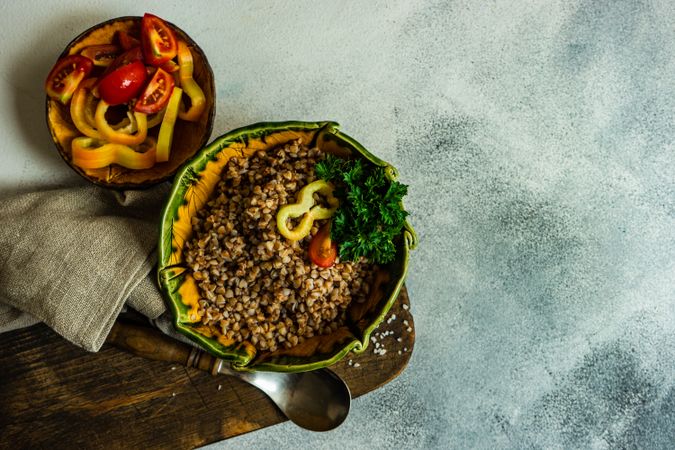 Top view of bowl buckwheat with tomatoes and mini peppers with copy space