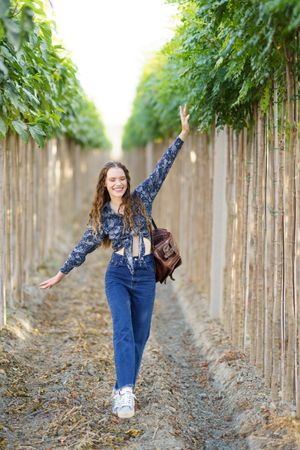 A young woman enjoys life walking through a scenic vineyard, taking in natures beauty
