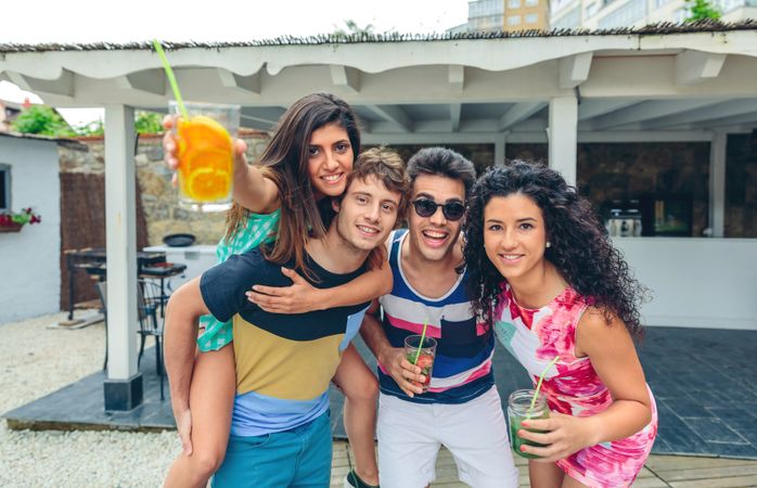 Group of friends enjoying cocktails at quiet outdoor bar