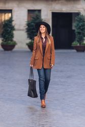 Gorgeous woman in fashionable outfit strolling on city street