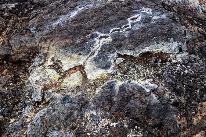 Geothermal area showing colorful sulfur deposits on volcanic rock