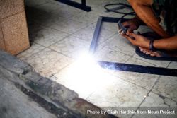Man welding a metal frame on the ground 5RROB5