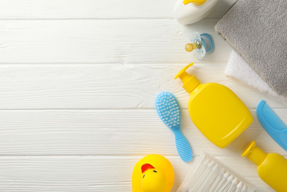 Baby hygiene accessories on wooden background, top view