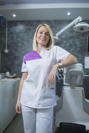 Female dentist leaning on chair in clinic