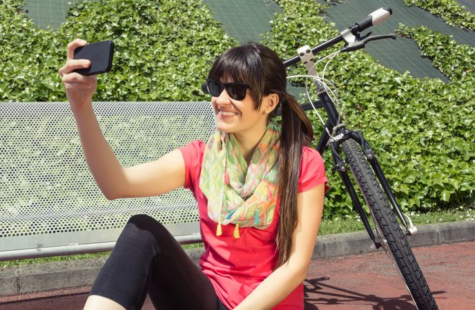 Sportive woman with fixie bike looking smartphone