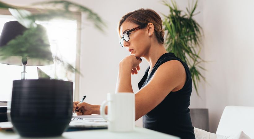 Side view of woman wearing glasses sitting at her desk in office