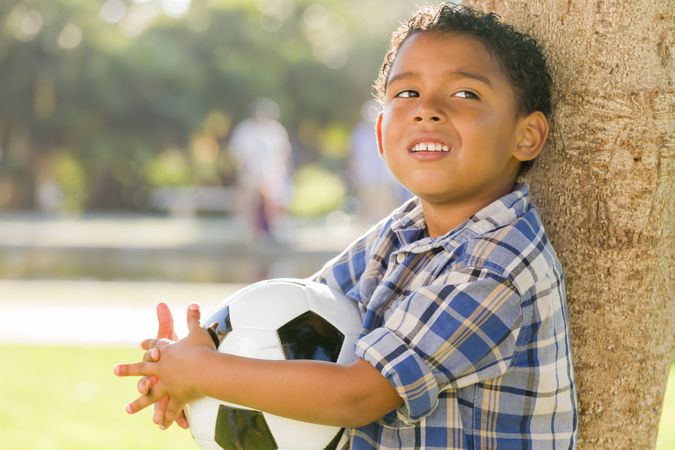 Smiling Boy Holding Soccer Ball in the Park