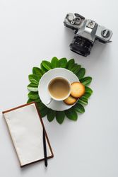 Morning coffee and green leaves in flower shape on light background