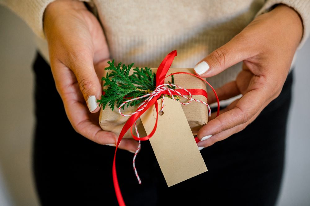 An unrecognizable woman holding Christmas gift in hand