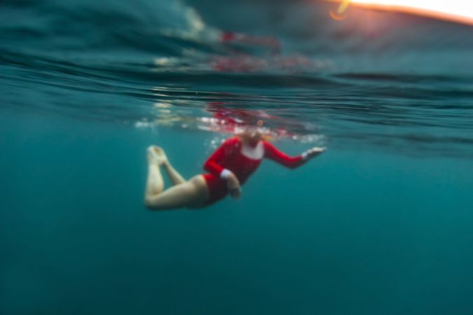 Woman diving in blue waving water