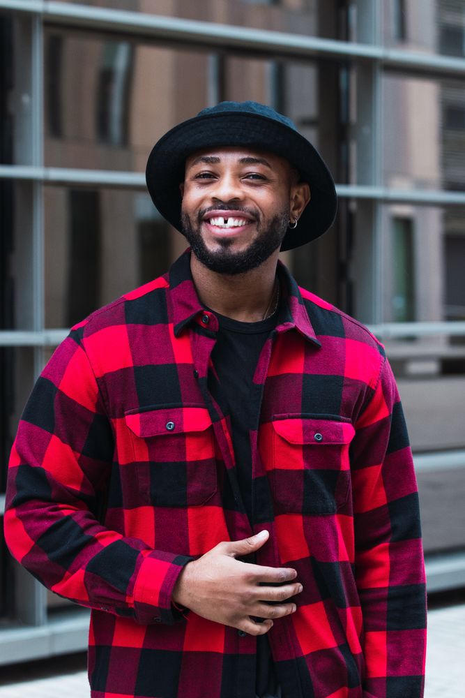 Cheerful Black man in stylish outfit on street