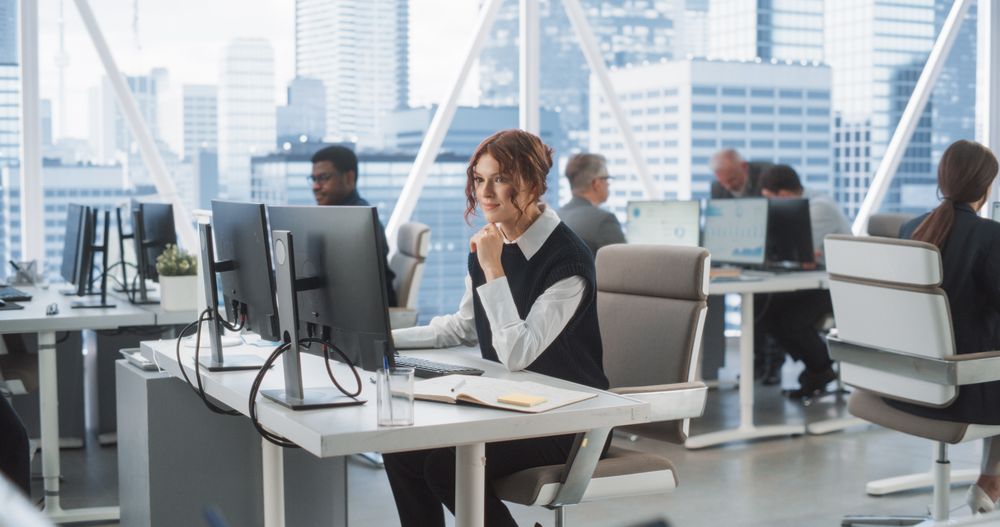 Woman Working In Tech Startup Company With Colleagues.