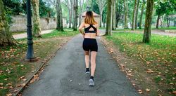 Female athlete running through a park