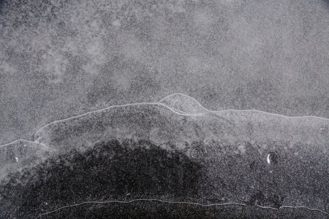 Fragment of thin ice on dark frozen river