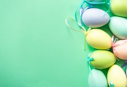 Easter card concept with pastel eggs on green background