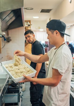 Kitchen staff with noodles for Japanese dish