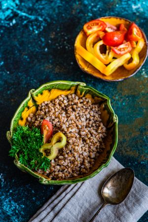 Top view of buckwheat with tomatoes and mini peppers in bowls