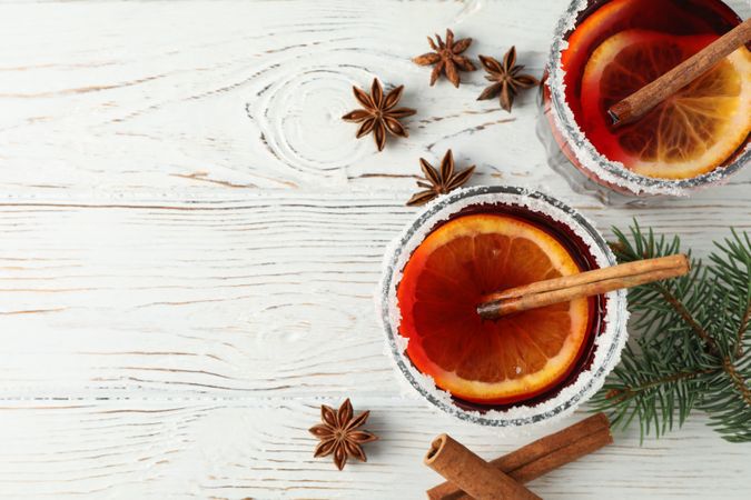 Glasses of tasty mulled wine on wooden background, top view