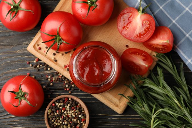 Composition with tomatoes and sauce on wooden background. Ripe vegetable