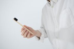 Man holding bamboo toothbrush