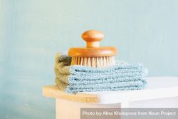 Bathing brush on stack of hand towels 0yp6Gb