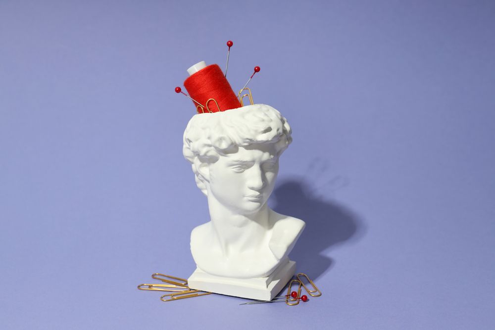 Pins and red spool in bust in purple space