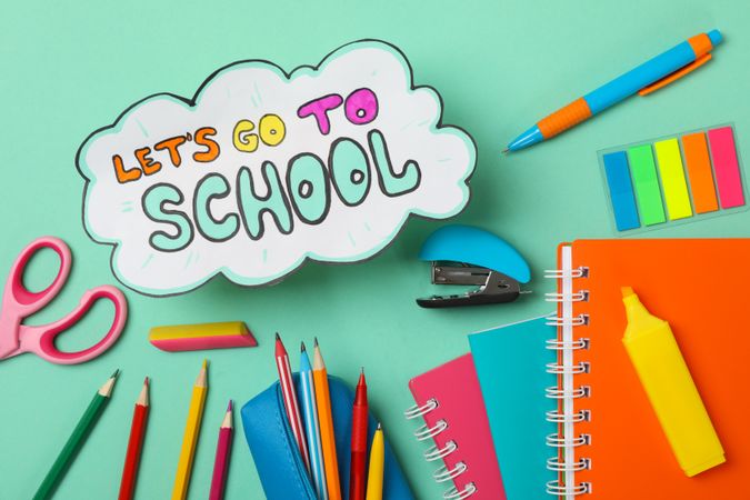 Text Let's go to school and school supplies on mint background