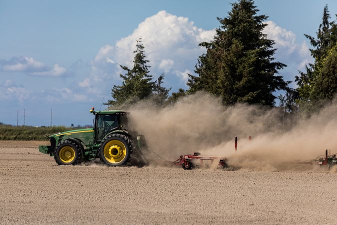 A farmer's tractor kicks up dust in a field outside La Conner, Washington
