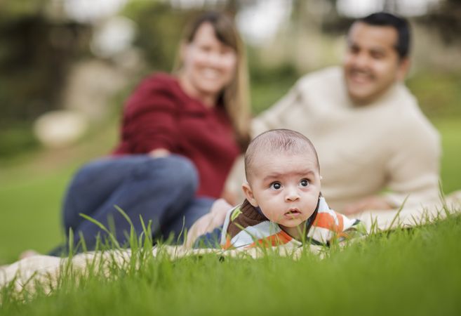 Happy Baby Boy and Parents Playing in Park