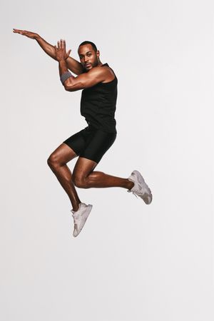 Portrait of Black athlete jumping in air
