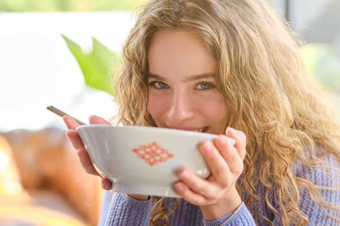 Positive woman with bowl of soup