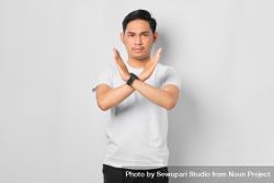 Asian male in grey studio with arms crossed in “x” 5kkWQ5