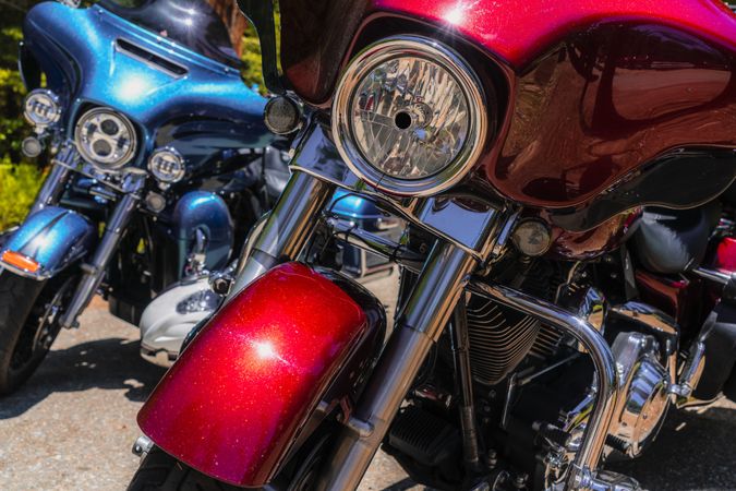 Red and blue motorcycles in street in sun day
