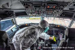 Worker in PPE disinfecting airplane control room at Soekarno-Hatta Airport 476vk5