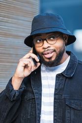 Happy hipster man getting good news during phone call