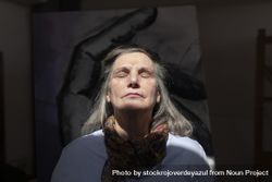 Mature artist woman enjoys the light that enters through a skylight 48BBmk