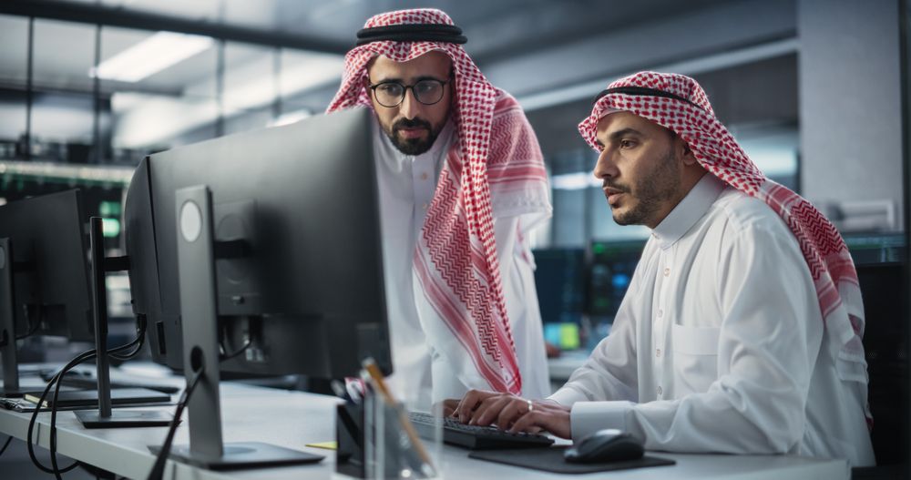 Two Multiethnic Arab Colleagues Having a Conversation While Busy Working on a Software Development Project.