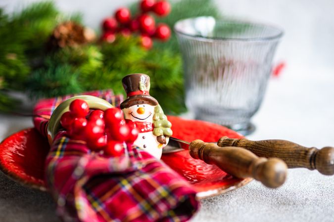 Tartan napkin with snowman ornament on Christmas table setting