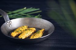 Endives with hollandaise sauce au gratin in pan on table