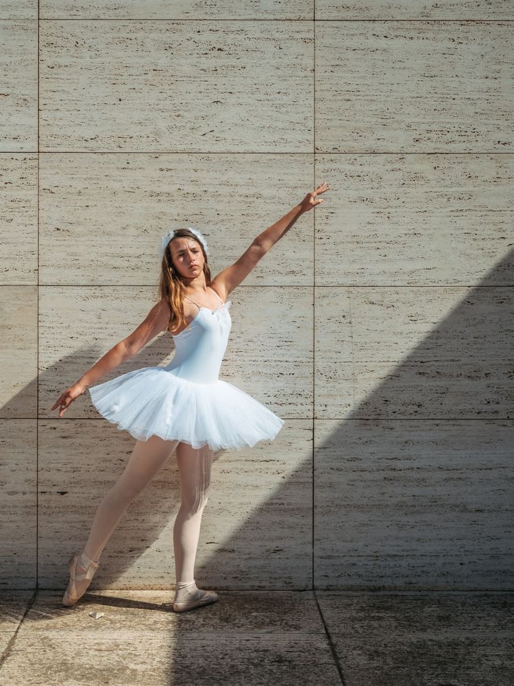 Ballerina doing ballet posing in classroom