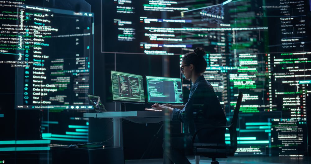 Professional Female Programmer Working in a Monitoring Control Room, Surrounded by Big Screens Displaying Lines of Programming Language Code.