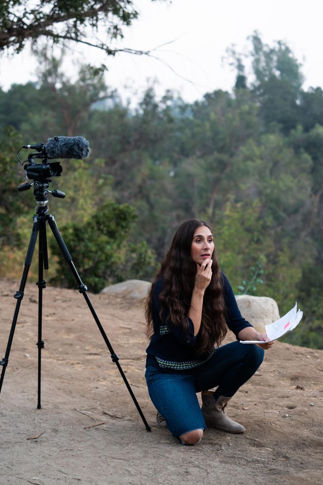 Female director kneeling down watching a scene with script in hand