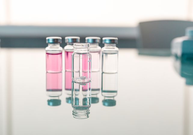 Vials with scientific samples arranged on glass table