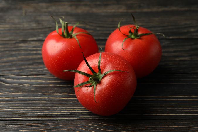 Fresh ripe tomatoes on wooden table, close up