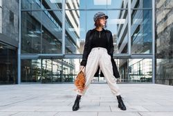 Stylish female holding flowers on street