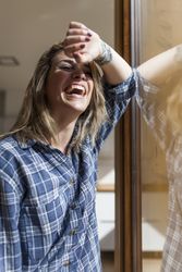 Woman at home leaning in a windows