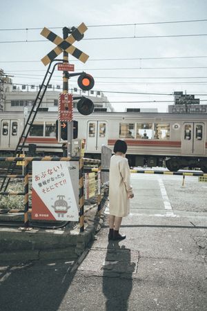 Woman in light standing beside a train