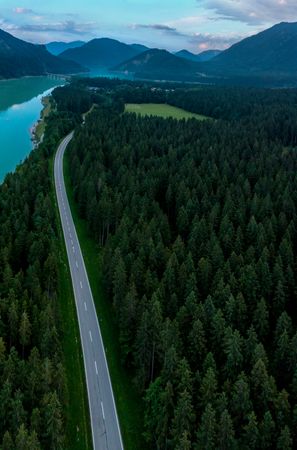 Drone aerial view with forest road on Sylvenstein lakeshore in Bavaria, Germany