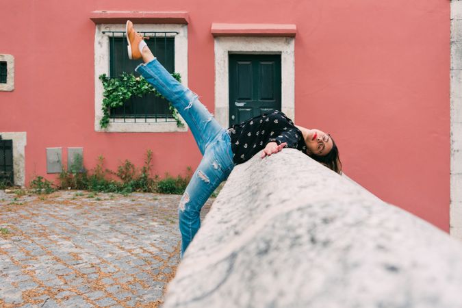 Casual woman dancing on old city street